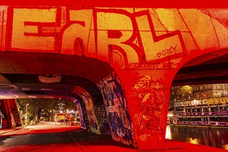 Illuminated, graffiti-painted bridge pillar of the Schwedenbrücke, night shot, Vienna, Austria,