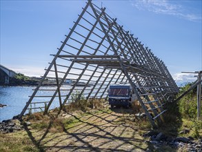 Mobile home, oldtimer, parking below wooden drying rack usually used to dry cod in winter,