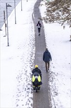 Winter in the city, cleared riverside path on the Main, jogger, walker, cyclist, cargo bike,