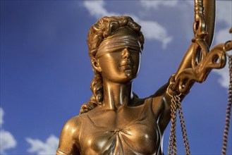 Close-up of a Justitia in front of a blue sky