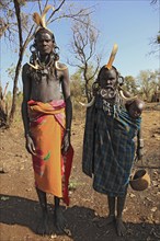 Southern Ethiopia, in Maco National Park, Mursi tribe, Mursi man, Mursi woman with baby, painted