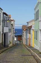 View of a historic street with colourful houses and the sea in the background, fishing village,