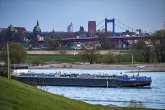 Cargo ship on the Rhine near Duisburg-Beeckerwerth, skyline of the city centre, with town hall,