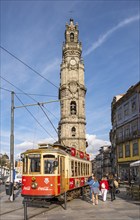 The iconic red tram number 18 pauses in front of the Clérigos Church Tower, Porto, Portugal, Europe