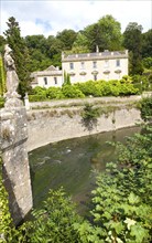 Classical facade of Iford Manor, Bradford on Avon, Wiltshire, England with a statue of Britannia on