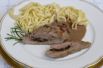 Swabian cuisine, lamb stuffed with prunes, rosemary, herbs, fillets arranged on plates,