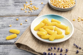 Jelly corn candies on gray wooden background and linen textile. close up, side view