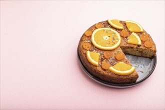 Orange cake on a pastel pink background. Top view, flat lay, copy space