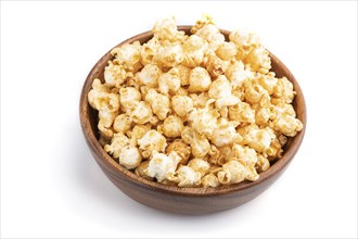 Popcorn with caramel in wooden bowl isolated on white background. Side view, close up