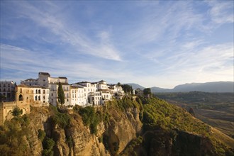 Historic buildings perched on sheer cliff top in Ronda, Spain, Europe