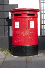 Large red traditional Royal Mail pillar box with two letter box openings, Royal Wootton Bassett,