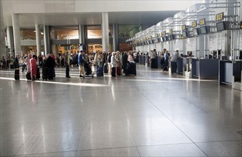 People waiting to check in inside Malaga airport, Spain, Europe