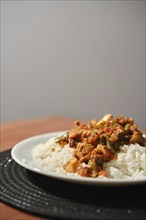 Close-up view of chicken ragout with vegetables and rice served on a plate