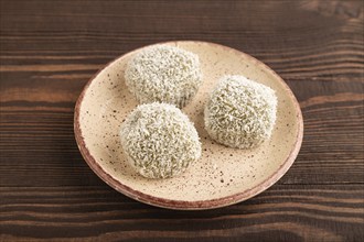 Japanese rice sweet buns mochi filled with pandan and coconut jam on brown wooden background. side