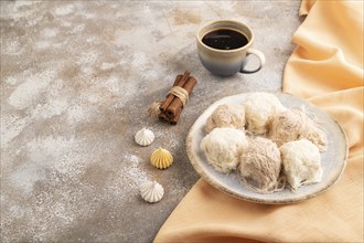 Traditional arabic sweets pishmanie and a cup of coffee on brown concrete background and orange