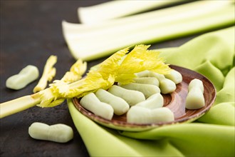 Jelly celery candies on black concrete background and green linen textile. close up, side view,