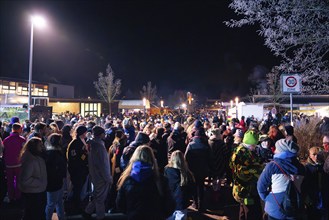 Crowd gathers outside at an evening carnival event, carnival, Schellbronn night parade,