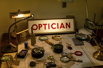 Optical items magnifying glasses labelled for sale with Optician illuminated sign, Marlesford Mill