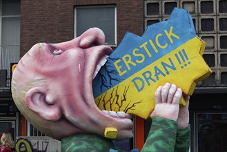 Vladimir Putin with his mouth open, devouring Ukraine, papier-mâché figure, satirical float by