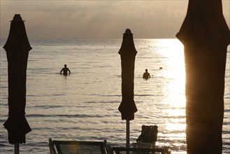 First swimmers at sunrise on the beach of Diano Marina, Italy, 14/08/2024, Diano Marina, Liguria,