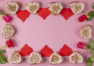 Frame made of heart-shaped cupcakes, red hearts and roses, Valentine's Day, pink background