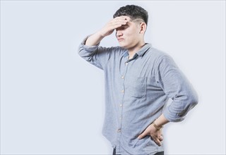 Tired man holding his head isolated. Worried young man holding his forehead isolated