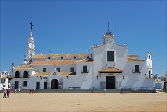 Eine weiße Kirche mit typischer spanischer Architektur vor einem klaren blauen Himmel und