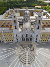 Aerial perspective of a baroque palace with high towers and a large, symmetrical square with a