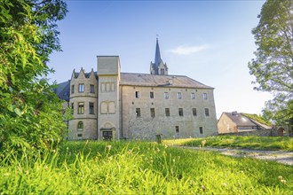 A castle building with many windows and high towers surrounded by green meadows, Harz Mountains,