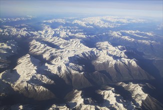 View from plane of snow covered mountain peaks in the Alps between France and Italy