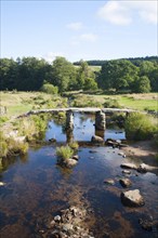 Historic medieval Clapper Bridge at Postbridge, Dartmoor national park, Devon, England crossing the