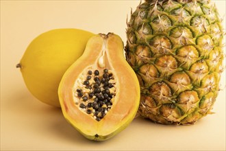 Ripe cut papaya, pineapple, melon, on orange pastel background. Side view, close up. Tropical,