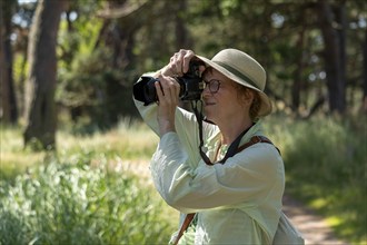 Woman taking photos, trees, circular hiking trail, Darßer Ort, Born a. Darß, Mecklenburg-Western