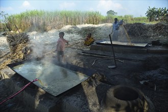 Workers boiling sugarcane juice as they are making Gur (jaggery) in a village on December 10, 2021