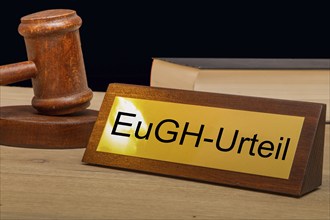 Symbolic image ECJ (European Court of Justice) : Judge's gavel next to a brass plate with the