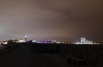 View of Warnemünde in the evening with the lighthouse and the Hotel Neptun, Warnemünde, 09.02.2023