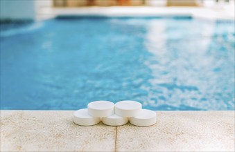 Close up of chlorine tablets on the edge of a swimming pool. Chlorine tablets for swimming pool