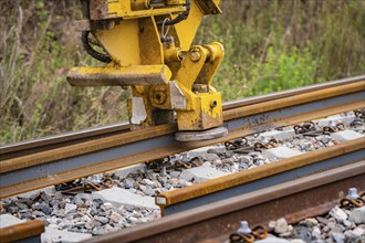 Close-up of a yellow construction machine working on a rail, track construction, Hermann Hessebahn,