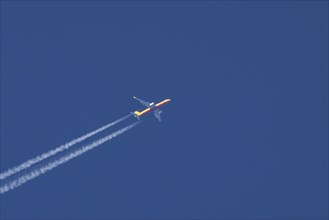 Boeing 767 jet cargo aircraft of DHL flying in a blue sky with vapor trails or contrails behind,