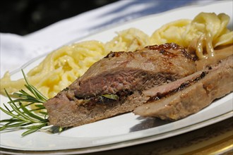 Swabian cuisine, lamb stuffed with prunes, rosemary, herbs, fillets arranged on plates,