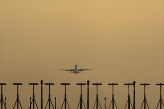 Boeing 737 jet passenger aircraft taking off at sunset, London Stansted airport, Essex, England,