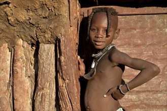 Himba girl at the door of her hut, Omohanja, Kaokoland, Kunene, Namibia, Africa