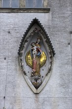 Sculpture of the Mother of God, Mary with the Child Jesus on a residential building facade,