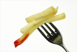 French fries with ketchup on fork