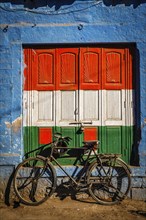 Bicycle and door painted in India national flag colors. Blue city of Jodhpur, Rajasthan, India,