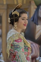 Fallas festival, woman in a traditional costume during the parade in the Plaza de la Virgen de los