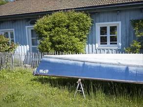 Boat and blue painted house on the Fraueninsel, Chiemsee, Bavaria, Germany, Europe