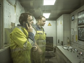 Workers in a control room of the double shield tunnel boring machine in section H53 of the Brenner