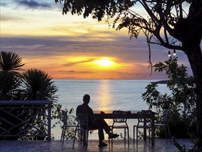 Person sitting on terrace by the sea, looking at the sunset, Bira, Sulawesi, Indonesia, Asia