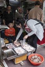 Stall selling duck giblets, including dried duck blood, an inexpensive foodstuff that is very